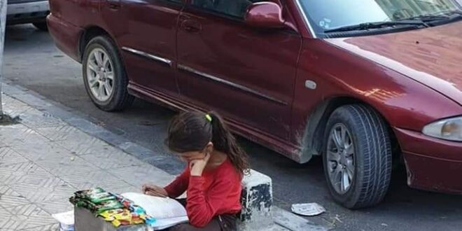 طفلة تقوم بواجبها الدراسي على أحد الأرصفة بدمشق.. و وزير التربية يتدخل؟